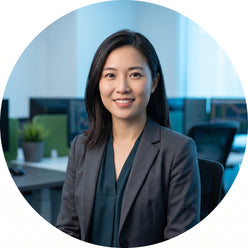 Professional portrait of Sarah Chen, a female financial trader, posed against a soft-focus professional office background.