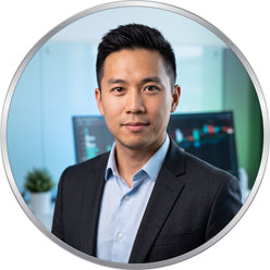 Portrait of professional trader Thomas Wu against a clean, modern background with soft green and blue lighting accents.